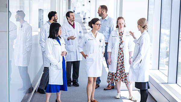 Cleveland Clinic caregivers talking in a hallway by a window.
