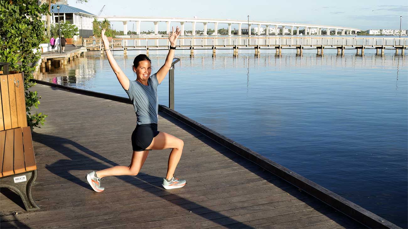 Stephanie smiling as she does her stretches before a run.