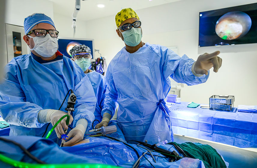 Provider in scrubs in OR pointing at an image