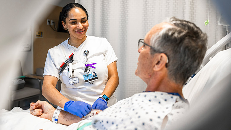 A Cleveland Clinic Caregiver checking on a patient in their room.